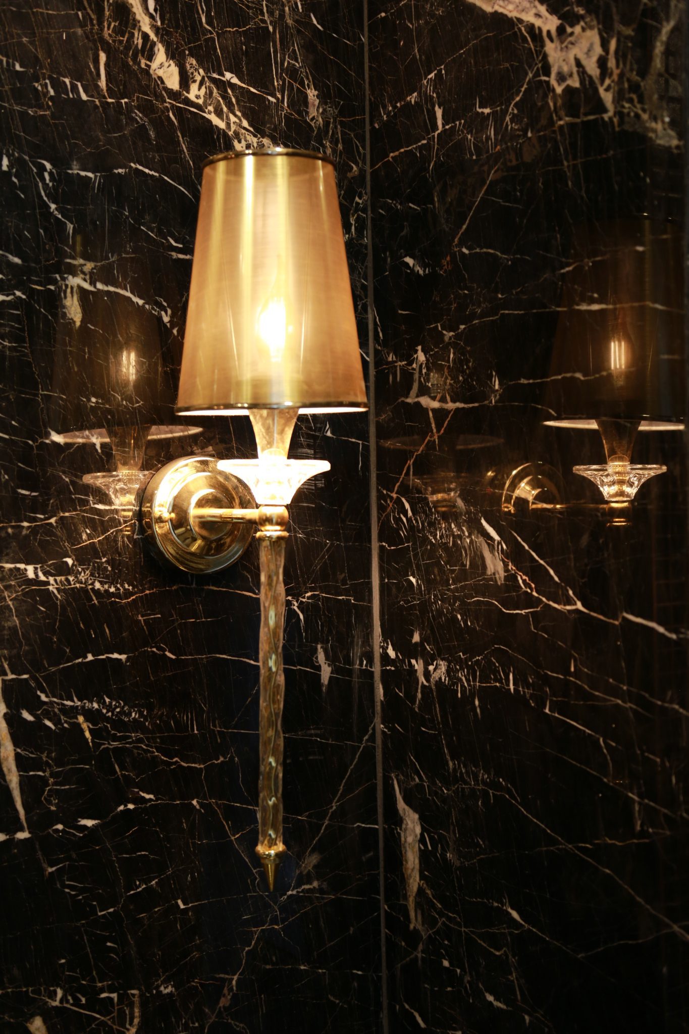 نمای لابی با چراغ‌های دکوراتیو و پوشش سنگ مرمریت نجف آباد برای طراحی لوکس و مدرن