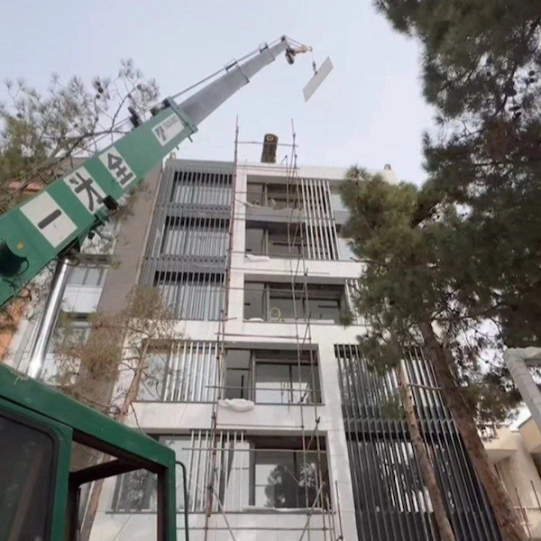 جرثقیل حامل صفحات گرانیتی به بالای ساختمان