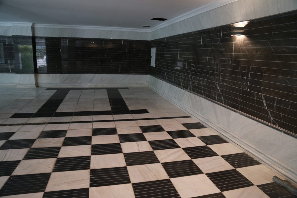 تصویری از پارکینگ یک ساختمان مجلل که در آن از سنگ های سیاه و سفید استفاده شده است