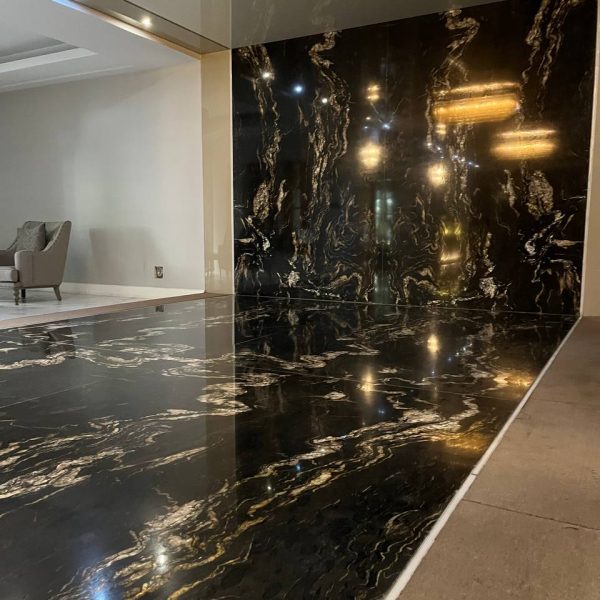 نمای زیبا از لابی لوکس یک ساختمان در تهران استفاده از سنگ گرانیت تیتانیوم هند با زمینه مشکی و رگه‌های طلایی در لابی - گروه سنگ المان
