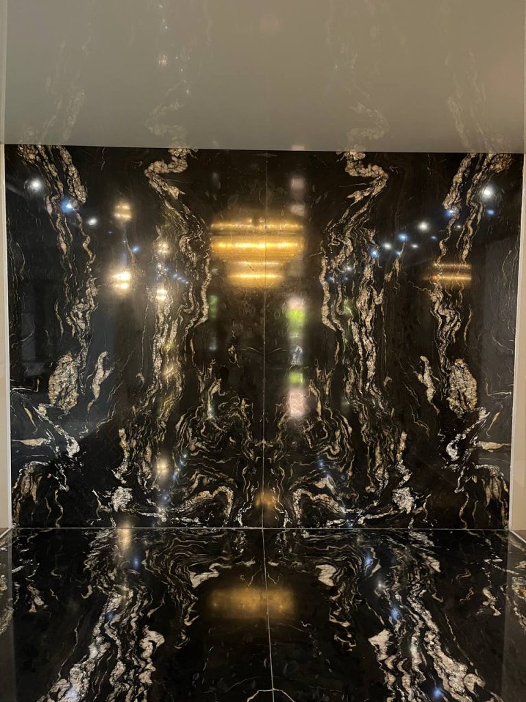 نمای زیبا از لابی لوکس یک ساختمان در تهران استفاده از سنگ گرانیت تیتانیوم هند با زمینه مشکی و رگه‌های طلایی در لابی
